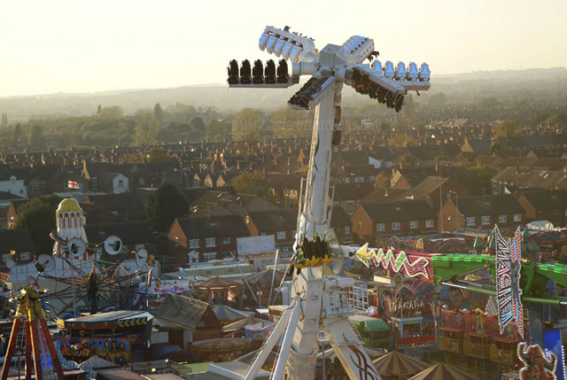 Image of Air sending its riders high above the houses and other rides at Hull Fair